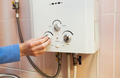 Man’s Hand Regulate The Power Of A Gas Hot Water System