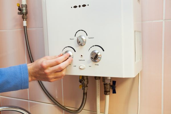 Man’s Hand Regulate The Power Of A Gas Hot Water System